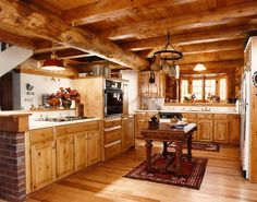 a large kitchen with wooden floors and walls, along with an island in the middle