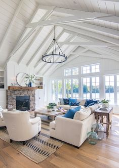 a living room filled with furniture and a fire place in the middle of an open floor plan