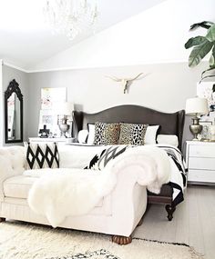 a white couch sitting in a living room next to a bed with pillows on top of it