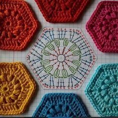 four crocheted hexagons are arranged on a sheet of paper