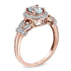 Honor her with a gift of elegance and beauty. This vintage-inspired gemstone ring is certain to capture her heart. Designed in precious 10k rose gold, this ring features a 7.0 x 5.0mm ice-blue oval-shaped aquamarine center stone surrounded by a halo of glittering diamonds. Intricate scroll work below the bezel enhances the ring's luxurious look while sparkling diamond accents form crowns on the shank, flanking the center arrangement and completing the style. Radiant with 1/6 ct. t.w. of diamonds, this ring is polished to a bright shine. Classic Rose Gold Rings With Accent Stones, Classic Rose Gold Birthstone Ring With Diamond Accents, Anniversary Birthstone Ring In Rose Gold With Diamond Accents, Anniversary Rose Gold Topaz Ring With Diamond Accents, Formal Rose Gold Birthstone Ring With Diamond Accents, Anniversary Rose Gold Birthstone Ring With Diamond Accents, Vintage Rose Gold Rings With Accent Stones, Classic Rose Gold Birthstone Ring With Center Stone, Classic Rose Gold Birthstone Ring With Accent Stones