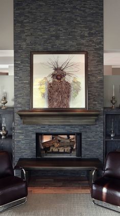 a living room filled with furniture and a fire place in front of a stone wall