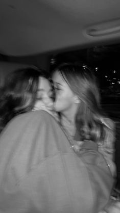 two women are kissing in the back seat of a car