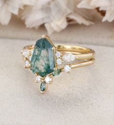 a green and white stone ring sitting on top of a flower