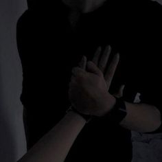 a person holding their hands together in the dark