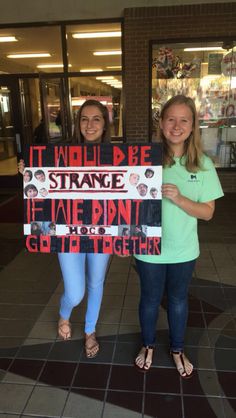 two girls holding up a sign that says it would be strange if the pin got to get together