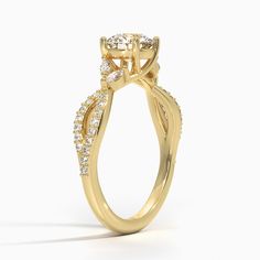 a yellow gold engagement ring with an oval shaped center stone surrounded by small round diamonds