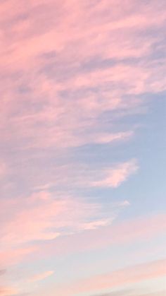 two airplanes are flying in the sky with pink and blue clouds behind them at sunset