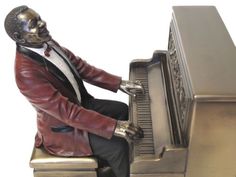 a statue of a man sitting at a piano