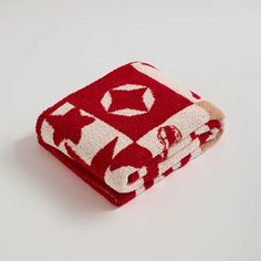 a red and white towel folded on top of each other in front of a white background