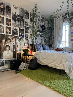 a bedroom with posters on the wall and a bed in front of a green rug