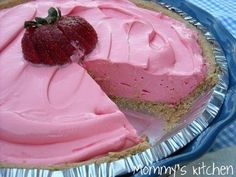 a strawberry cream pie with a slice taken out of it on a blue platter