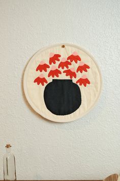 a wall hanging on the side of a white wall with red fish coming out of it