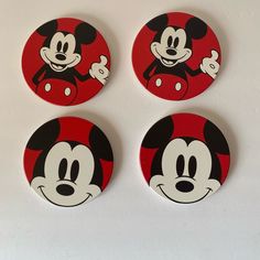 four mickey mouse magnets on a white surface