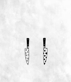 three knives with hearts on them are hanging from the wall, one is black and white