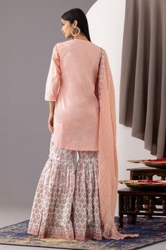 Rose pink short kurta with polka dot hand block print and lace embroidered placket, neckline. Paired with floral print gharara and dupatta.
Component: 3
Pattern: Printed
Type Of Work: Polka Dots, Floral
Neckline: Round
Sleeve Type: Three quarter
Fabric: Kurta and Gharara - Cotton Cambric, Dupatta - Cotton Mulmul
Color: Pink
Other Details: 
Front button detailing
Rounded hem
Side tassel tie-up
Contrast dupatta
Tiered gharara
Occasion: Sangeet - Aza Fashions Cotton Sharara With Cutdana For Wedding, Cotton Cutdana Sharara For Wedding, Cotton Sharara For Wedding, Wedding Cotton Sharara With Cutdana, Unstitched Cotton Sharara For Wedding, Cotton Sharara With Dabka Traditional Drape, Traditional Cotton Sharara For Wedding, Cotton Sharara For Wedding Diwali, Pink Cotton Sharara With Dabka Details