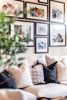 a living room filled with lots of pictures on the wall and furniture in front of it