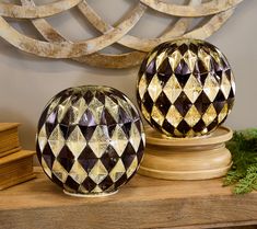 two decorative vases sitting on top of a wooden table