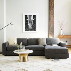 a living room with a couch, coffee table and lamp on the floor in front of it