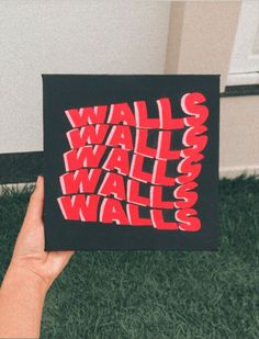 someone is holding up a card with the words wall and walls printed on it in red