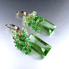 These green focal stones are absolutely stunning! They are celery green quartz in a baguette cut and the step cut faceteing is beautiful. The focals measure 21x10mm., with dozens of shaded green tsavorite and green amethyst rondelles draping down around the focals stones. The earrings measure 1 7/8 from the top of the gold filled lever back ear wires. I can easily switch out the lever backs for simple French style ear wires. Simple French Style, Celery Green, Wire Work Jewelry, Step Cut, Work Jewelry, Green Quartz, Cluster Earrings, Baguette Cut, Green Amethyst