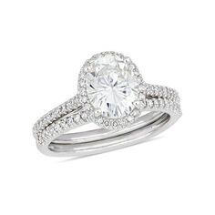 a white gold ring with an oval cut diamond in the center and two rows of pave set diamonds on each band