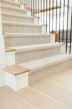 the stairs are lined with white carpet and wood