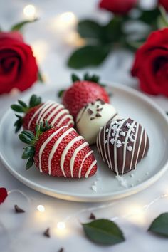 three chocolate covered strawberries on a white plate with red roses in the back ground