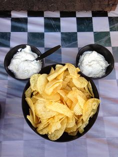 two black bowls filled with chips and dips