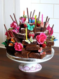 a cake that is sitting on top of a table with candles and flowers in it