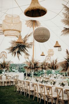 an outdoor wedding reception with palm trees and hanging lanterns