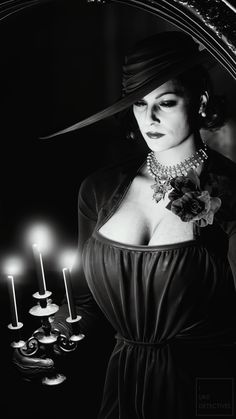 black and white photograph of a woman with candles in front of her, wearing a hat