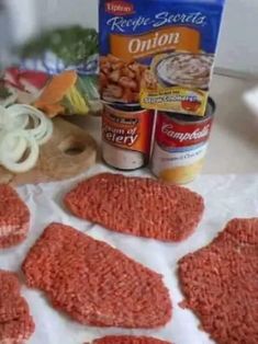 raw ground meat is laid out on a table next to canned food and seasonings