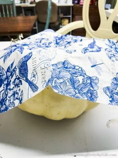 a blue and white pillow sitting on top of a table