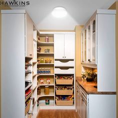 a kitchen with white cabinets and lots of pantry items on the shelves in front of it