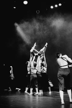 a group of people standing on top of a stage with their hands in the air