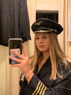 a woman in a sailor's outfit taking a selfie with her cell phone