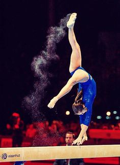 a woman on the balance beam doing a handstand