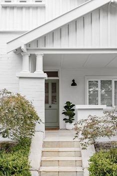 a white house with steps leading up to the front door