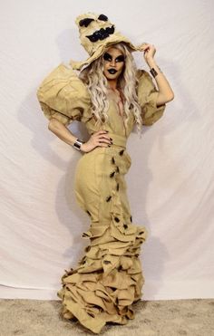 a woman in a dress and hat posing for the camera