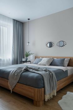 a bedroom with a large bed and two mirrors on the wall