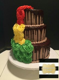 three tiered chocolate cake decorated with colorful icing