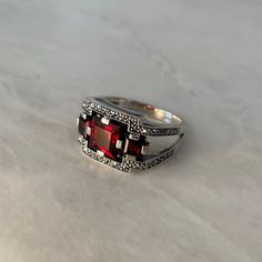 If your size is in stock, your order will be delivered within 2 to 3 working days; otherwise an adjustment will be made within 8 to 10 days (you will then be informed by message). > Material and stone: silver, garnet, marcasite > Dimensions: 1.2 cm (length) x 1.8 cm (width) > Free delivery in France > Free Valkyrie box and pouch > Ring guaranteed for one year against any manufacturing defect > Hypoallergenic ring Opt for garnet, a timeless stone with surprising virtues. The Orion art deco ring i Art Deco Rings With Accent Stones, Art Deco Silver Gemstone Ring, Art Deco Promise Rings With Accent Stones, Art Deco Promise Ring With Accent Stones, Art Deco Sterling Silver Rings With Center Stone, Art Deco Sterling Silver Ring With Center Stone, Art Deco Rings With Accent Stones For Gifts, Art Deco Ring With Accent Stones For Gifts, Art Deco Ring With Accent Stones Gift