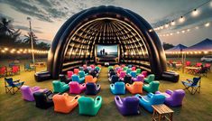 an inflatable stage set up with chairs and tables for outdoor movie viewing at dusk