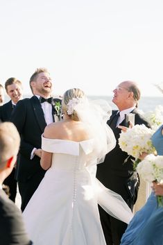 the bride and groom are laughing as they walk down the aisle at their wedding ceremony