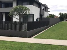 a black and white house with trees in the front yard