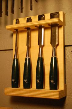 a set of knives hanging on a wooden rack