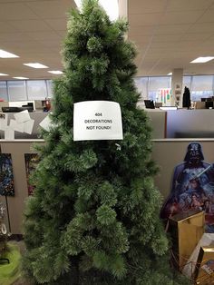 a fake christmas tree in an office cubicle with star wars decorations on the wall