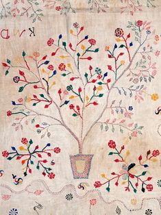 an embroidered tree with flowers and birds on it