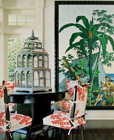 a dining room with chairs and paintings on the wall in front of it's windows